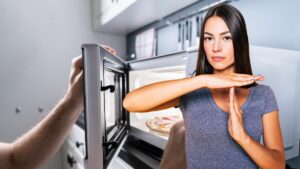 mano che apre microonde e donna che fa segno stop con le mani