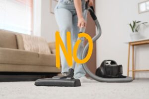 donna che passa aspirapolvere e scritta no
