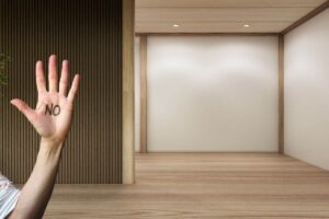 stanza di una casa vuota con parquet e mano con scritta no