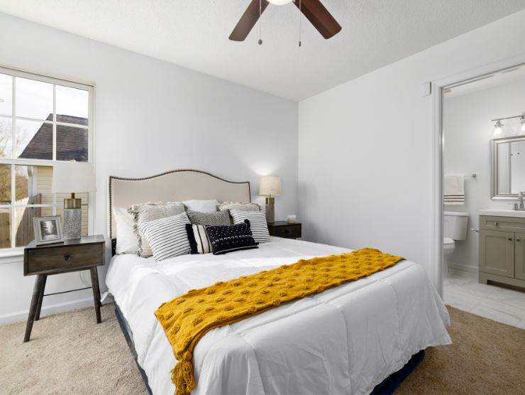 camera da letto con letto bianco con cuscini e plaid