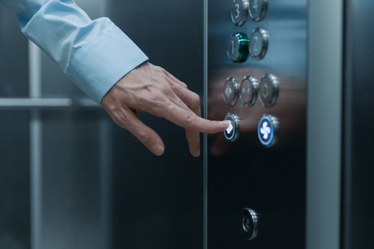 Una persona che preme un tasto dell'ascensore 