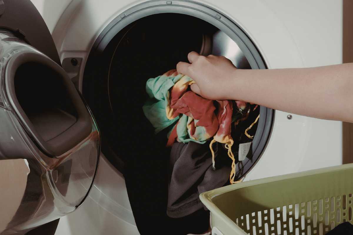 mano che prende panni in asciugatrice 