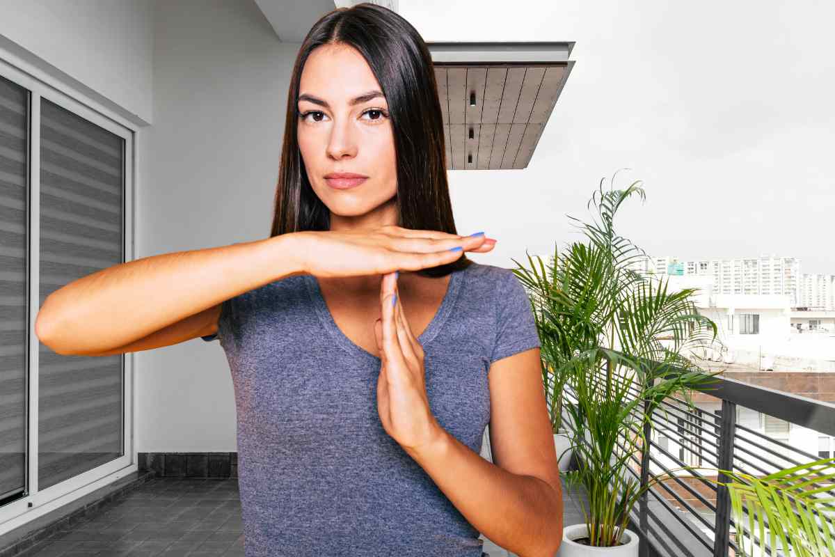 donna che fa segno stop con la mano e sfondo di un balcone vuoto