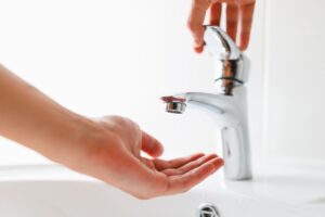 Una persona che apre il rubinetto ma non esce l'acqua
