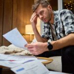 Una persona preoccupata mentre legge le bollette