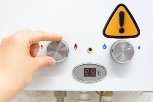 caldaia e mano con simbolo attenzione giallo e nero