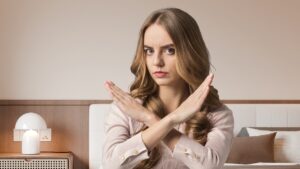 camera da letto e donna che fa segno di no con le mani