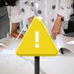 persone che guardano fogli e triangolo giallo attenzione