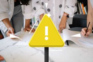 persone che guardano fogli e triangolo giallo attenzione