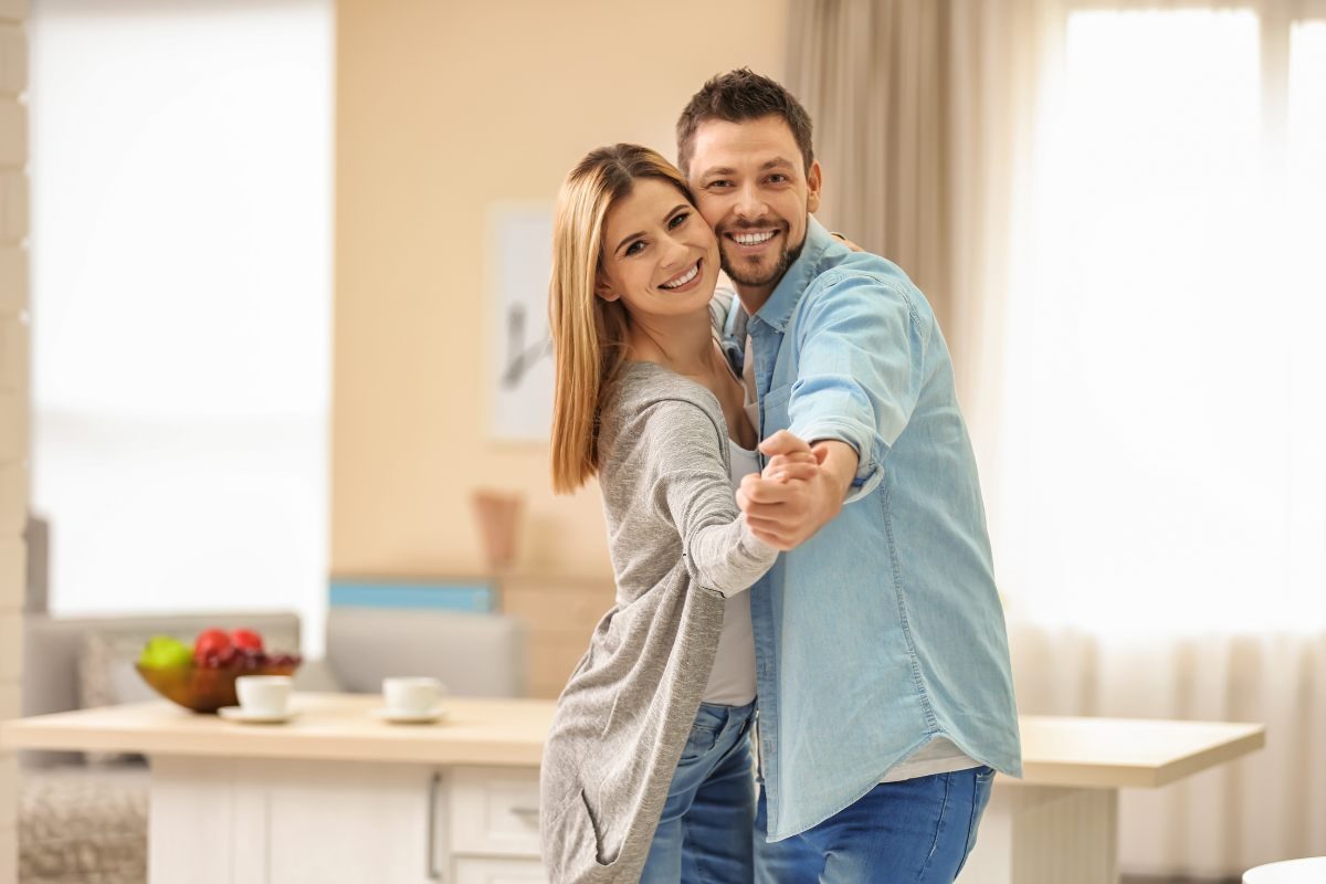 Una coppia nella propria casa che è felice e balla