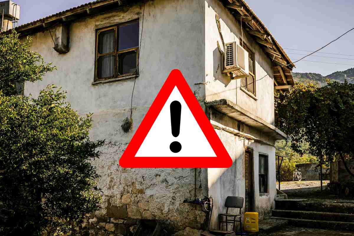 Una casa occupata con davanti un segnale di pericolo