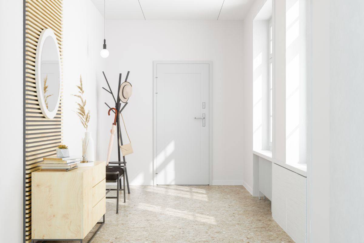 ingresso di casa con pareti bianche, mobile e attaccapanni