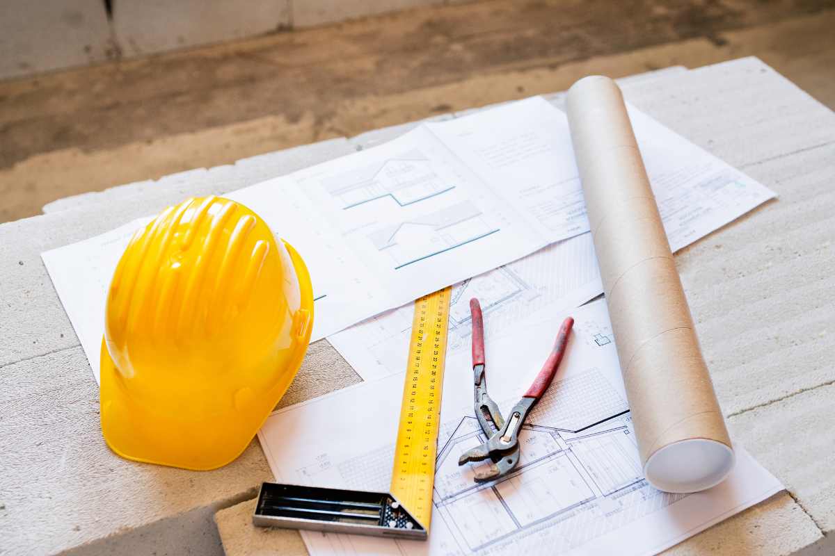 fogli, cappelletto cantiere giallo, martello