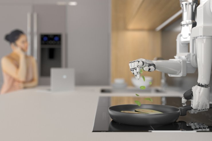 Una persona che parla al telefono mentre un robot cucina