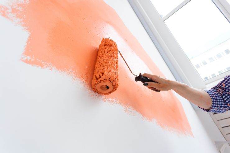 Un operaio che tinteggia i muri