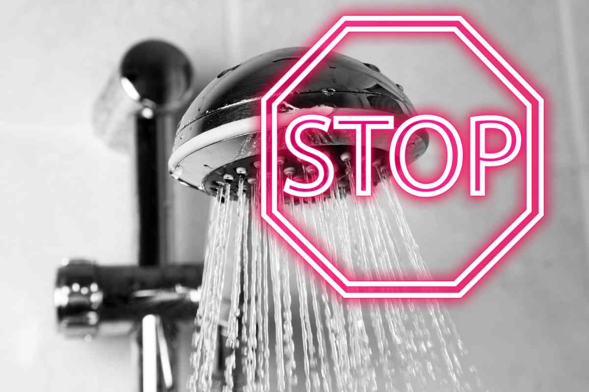 doccia con mattonelle ed acqua aperta con scritta stop in rosso