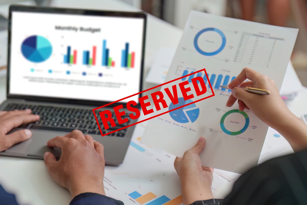 Due persone che analizzano dei dati e una scritta in primo piano in rosso "reserved"