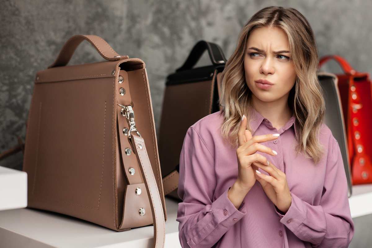 donna dubbiosa con borse dietro di lei