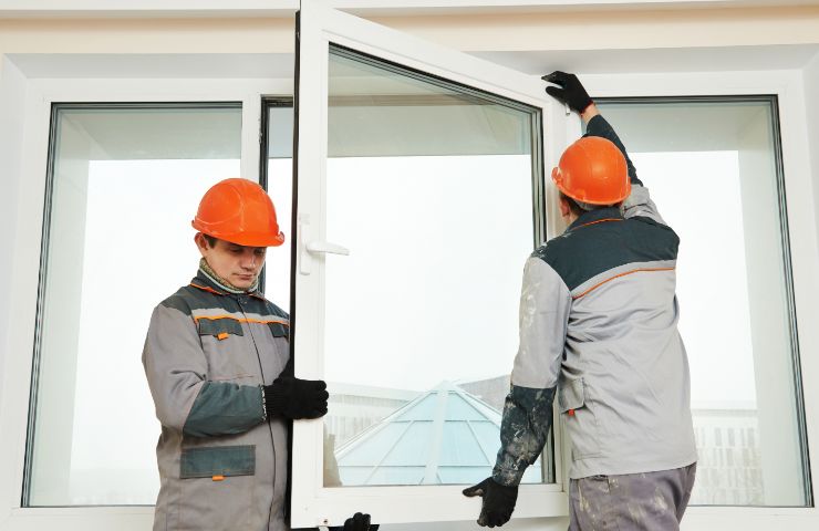 tecnici con infisso nuovo in mano