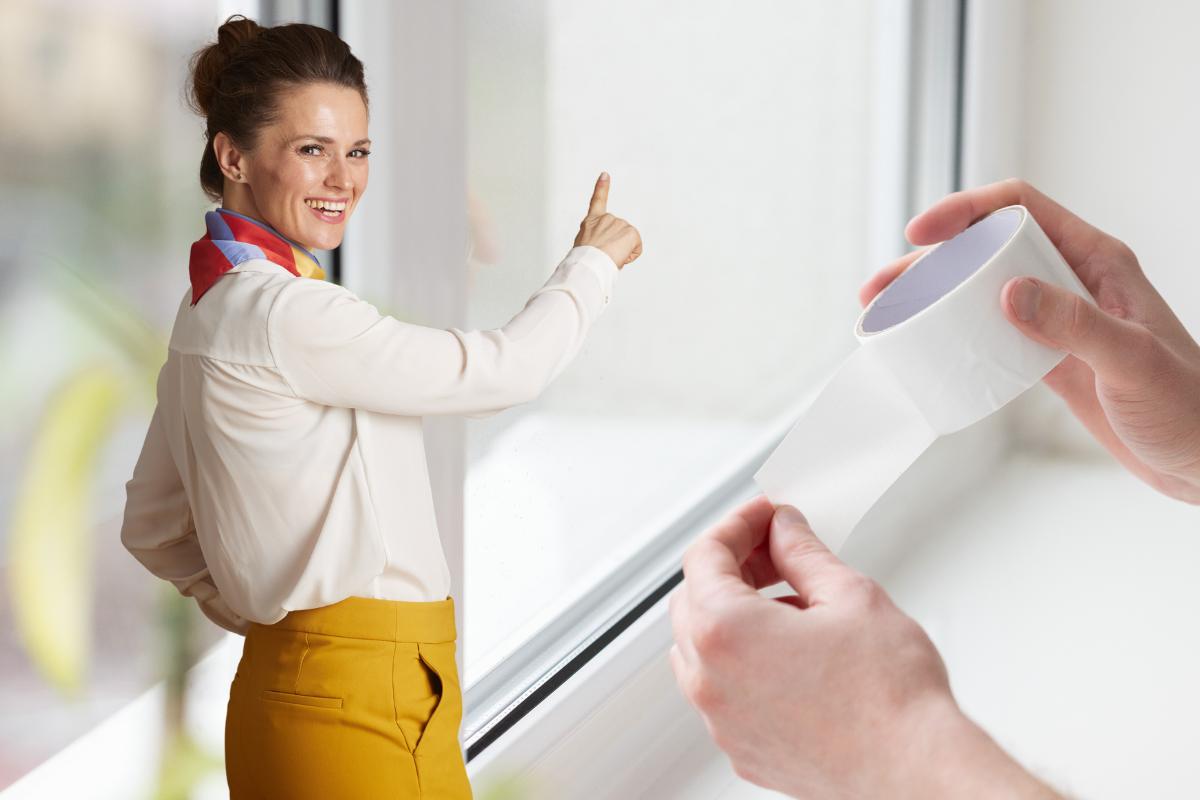 donna che indica finestra con mani e schotch