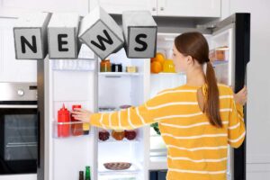 donna che apre frigorifero e scritta news