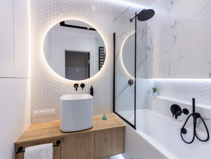 bagno moderno con doccia, lavandino e specchio acceso