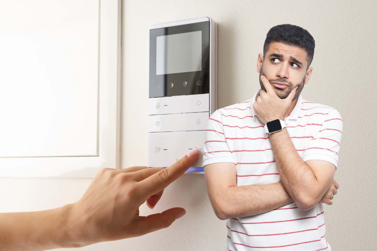 mano su termostsato in casa e uomo con idea