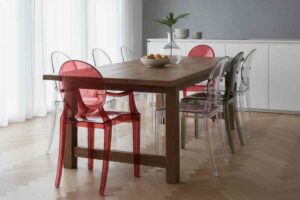 tavolo da pranzo di legno scuro con sedie kartell trasparenti