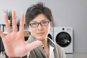 Uomo che fa segno di fermarsi con la mano ed asciugatrice dietro