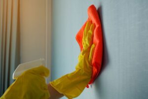 persona che pulisce parete di casa