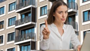 palazzina sullo sfondo e donna al pc con mano che indica no