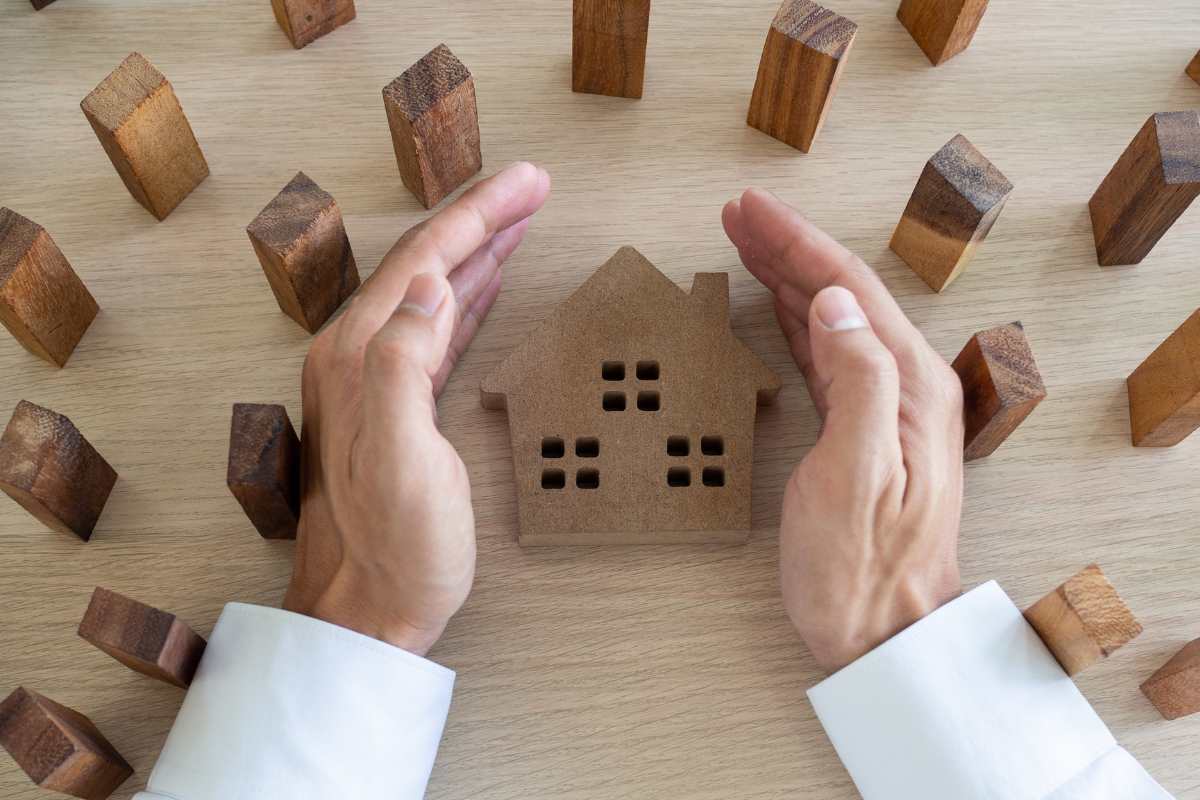 mani che proteggono casa in legno 