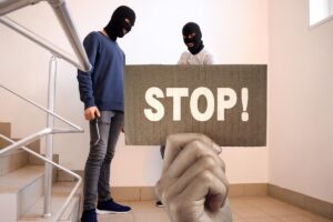 ladri sulle scale di casa e mano con cartello e scritta stop