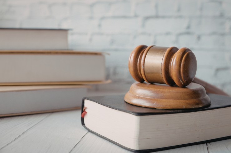 Dei libri di legge ed un martello da giudice su un tavolo