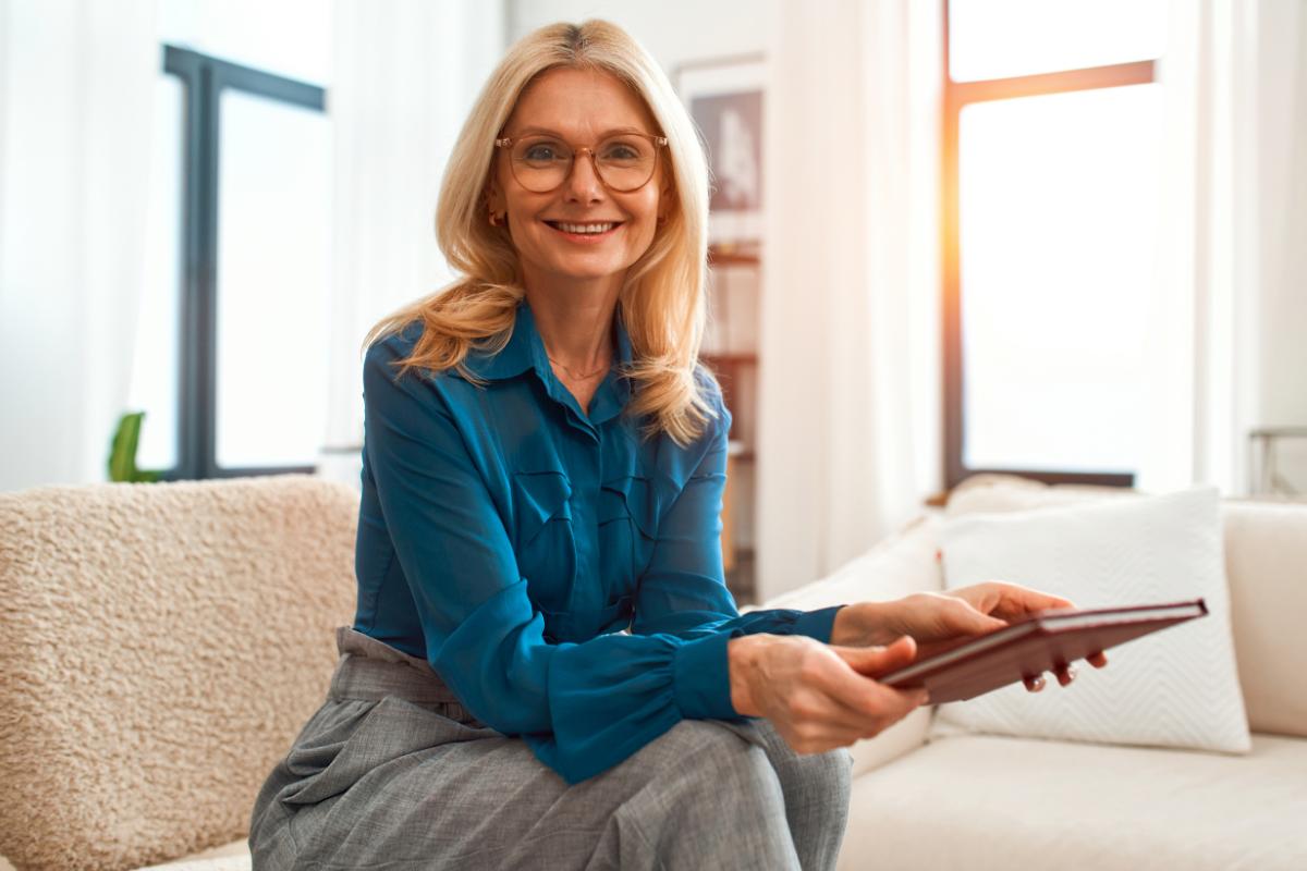 Una psicologa seduta con un quadernino chiuso tra le mani