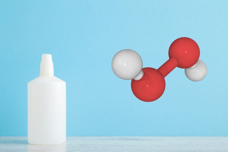 Una boccetta di perossido di idrogeno e sulla destra una molecola di perossido di idrogeno