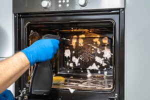 Una persona che pulisce il forno