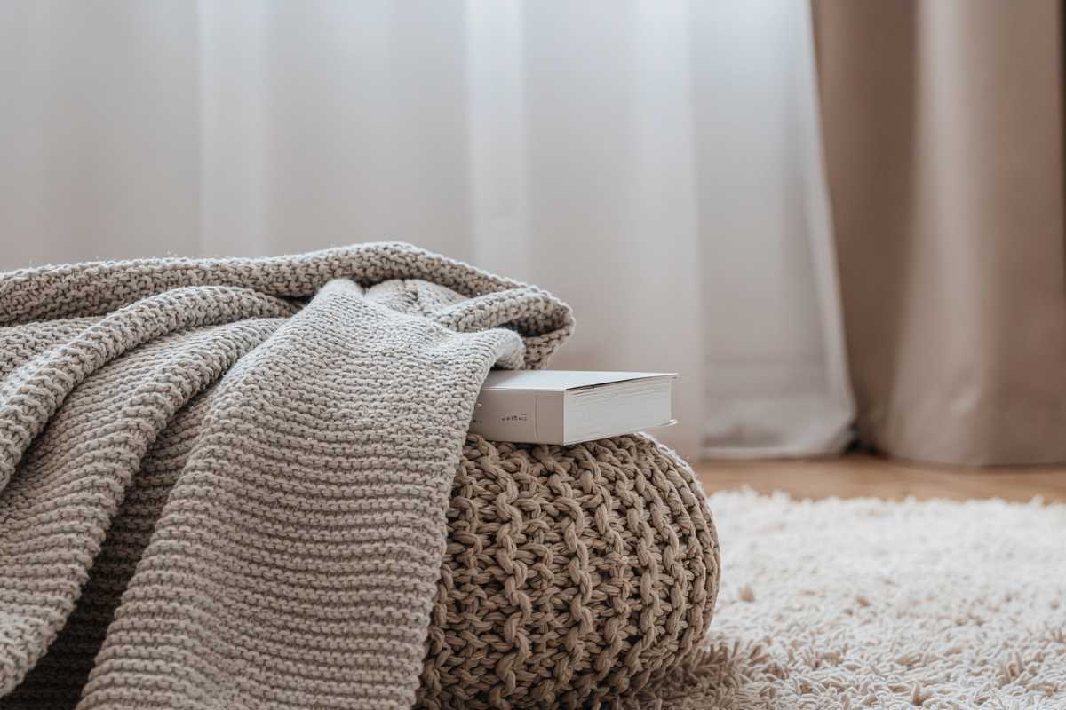 pouf con coperta e libri sopra 