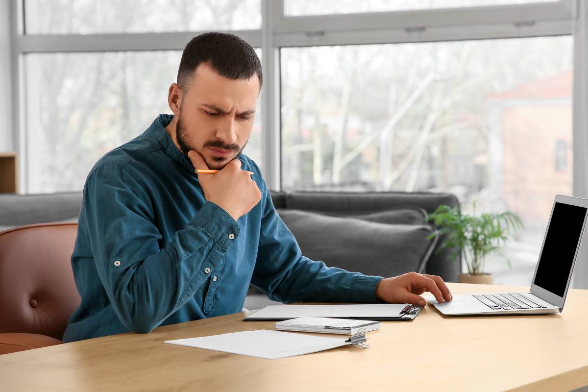 uomo che pensa mentre legge fogli