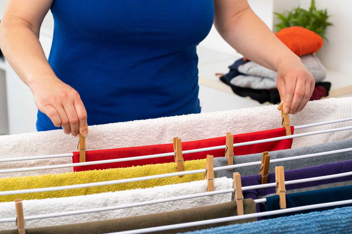 Una donna che mette i panni sullo stendibiancheria