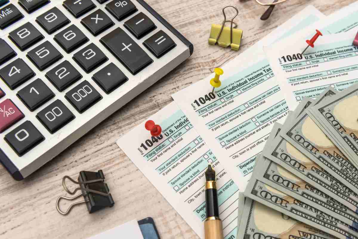 soldi con fogli delle tasse e calcolatrice 