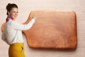 tagliere e donna che lo indica sorridendo