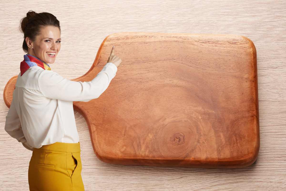 tagliere e donna che lo indica sorridendo