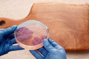 Tagliere in legno e mani con germi e guanti