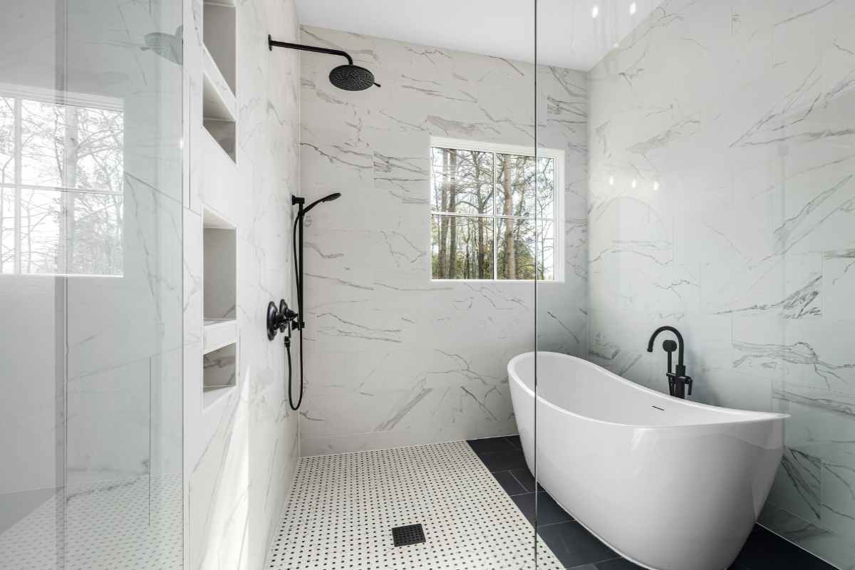 open glass shower in the bathroom and bathtub nearby 