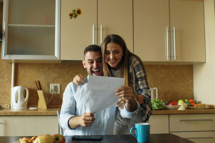 Una coppia che legge un foglio ed esulta