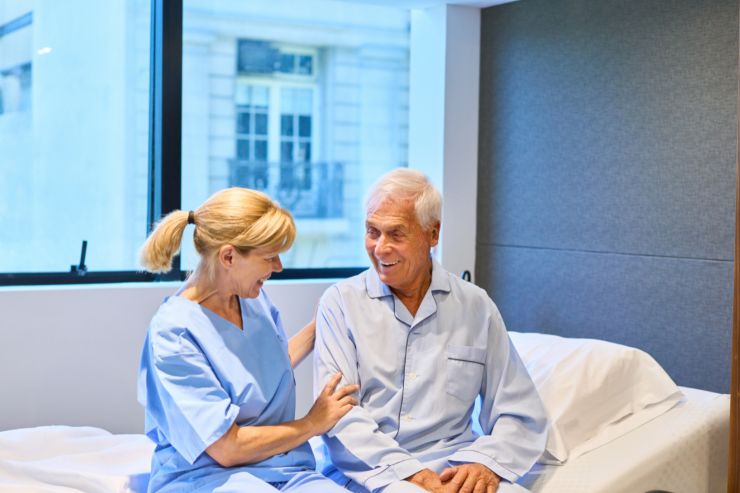 Un signore anziano assistito su un letto