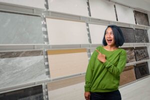 Diverse piastrelle in vendita ed una donna che le indica contenta