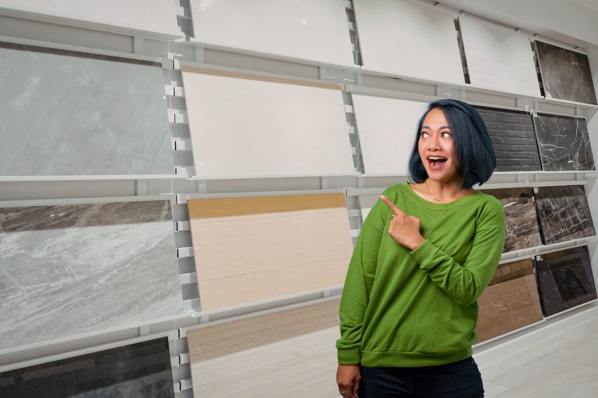 Diverse piastrelle in vendita ed una donna che le indica contenta