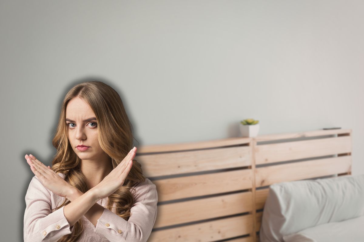 testiera letto in legno e donna che fa stop con le mai